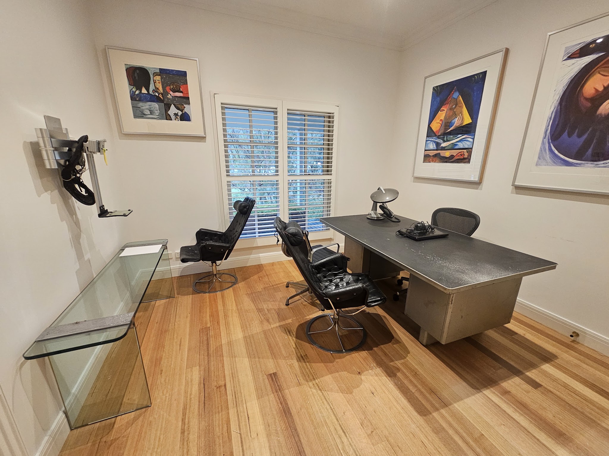 Home study with freshly painted white walls, timber floor and a desk